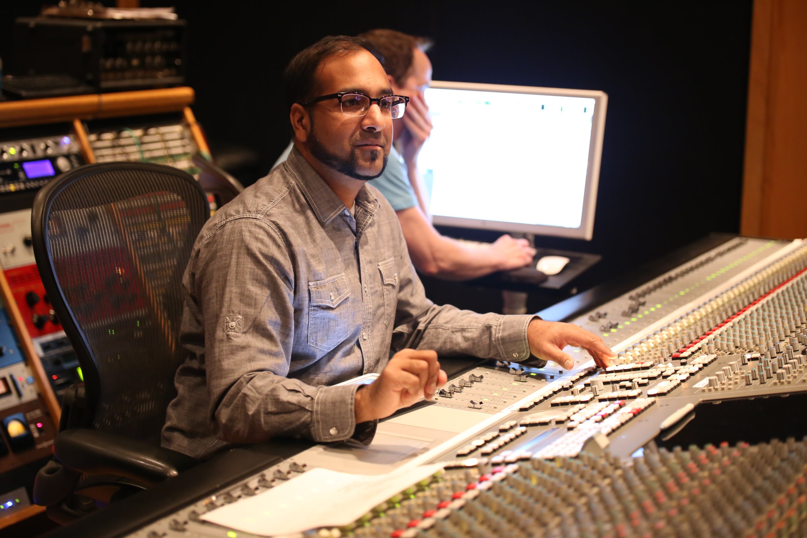 Roy Oommen at a large-format mixing console during a session